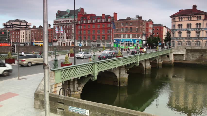 DUBLIN - JUNE 10: Cars and passers-by cross the Grattan bridge over river Liffey with wooden railings , June 10, 2010 in Dublin, Ireland. Grattan Bridge is a road bridge spanning the River Liffey in Dublin, Ireland, and joining Capel Street to Parliament 
