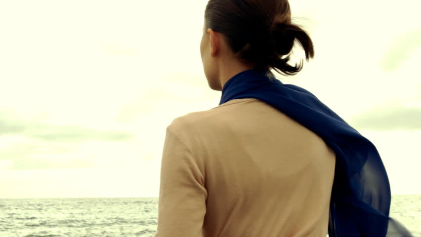 Young woman thoughtfully looking out to sea