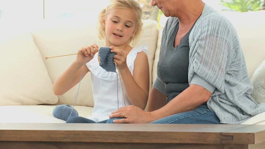 Girl learning to knit with her grand mother