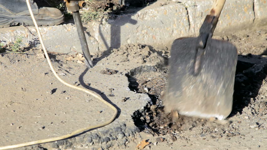 Road construction worker operates a pneumatic jack hammer