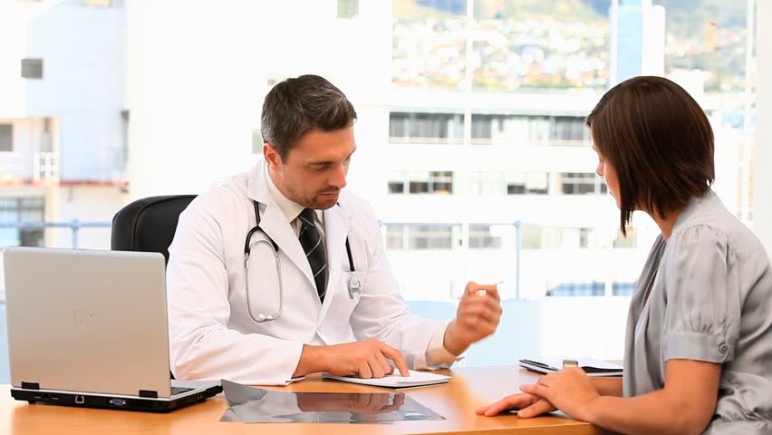 Patient taking a prescription from her doctor at the surgery