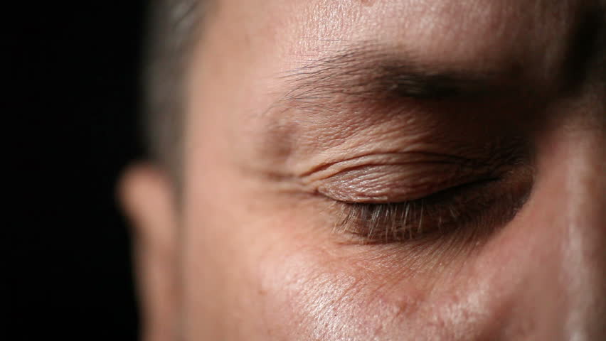 Closeup of adult man eye against dark background 