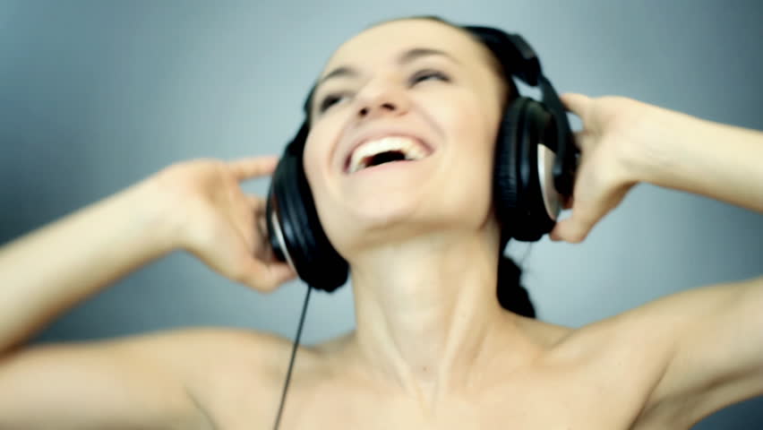 Beautiful woman with headphones listen to the music on blue background