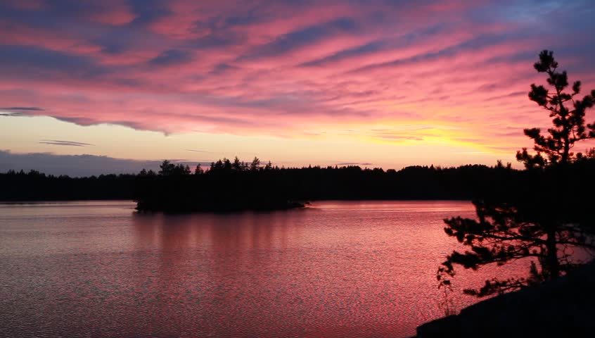 Wonderful pink sunset on forest lake, Karelia, Russia
