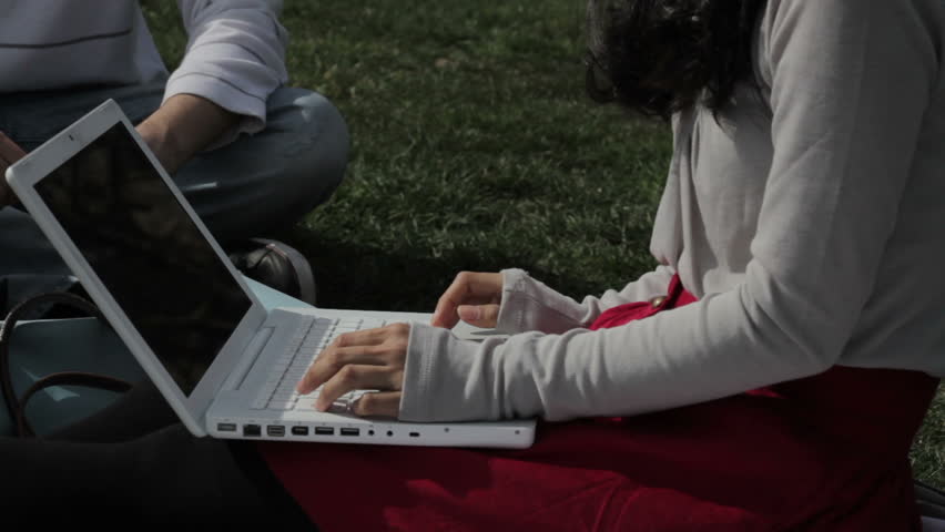 girl with laptop sitting in the grass