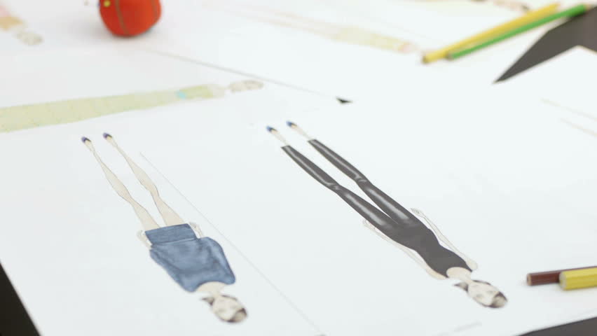 Dressmaker sketching and drawing new dresses and models. Dolly shot