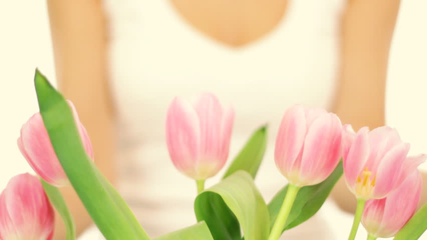 Young romantic woman smell spring tulips, isolated