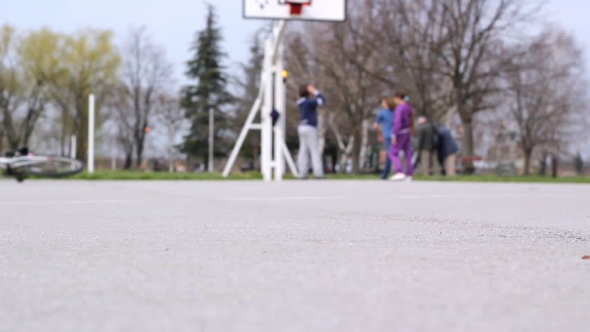 Group of teenagers playing basketball and skateboarding at playground.  HD 1080p.