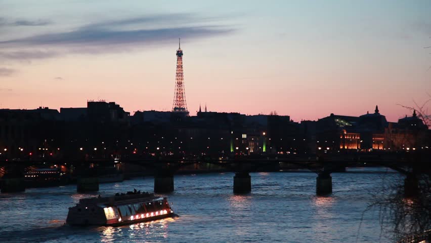 ship moves on river to iron bridge of night in Paris
