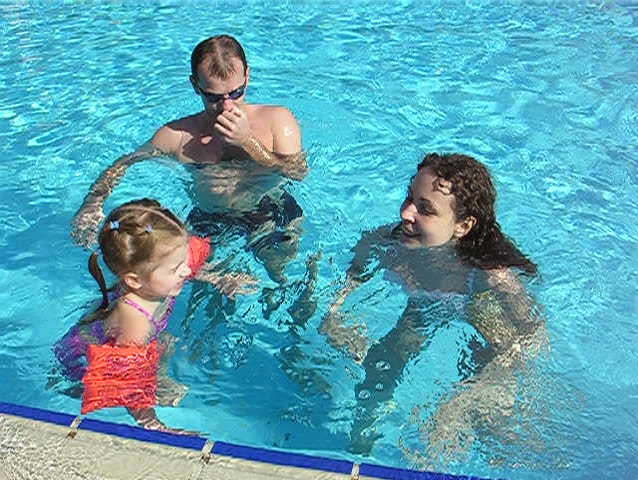 family in tropical pool