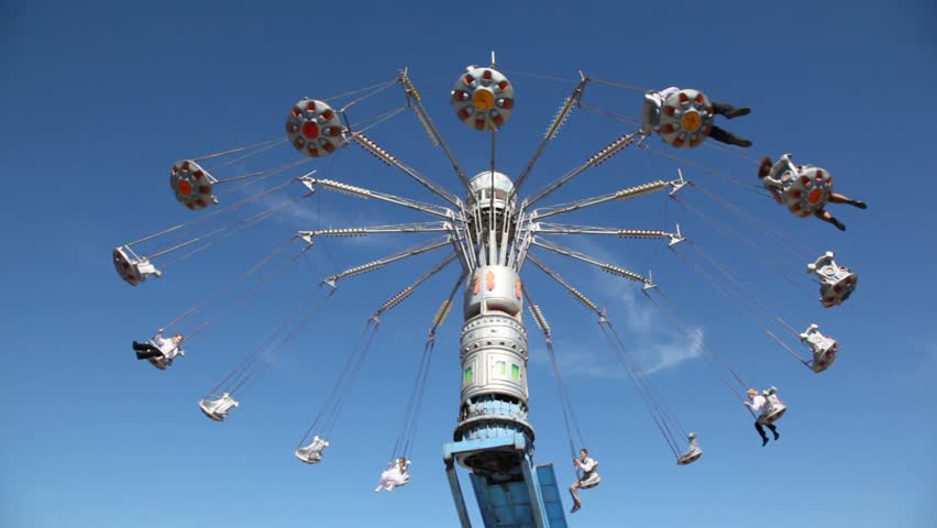 Merry-go-round on blue sky background at sunny day.