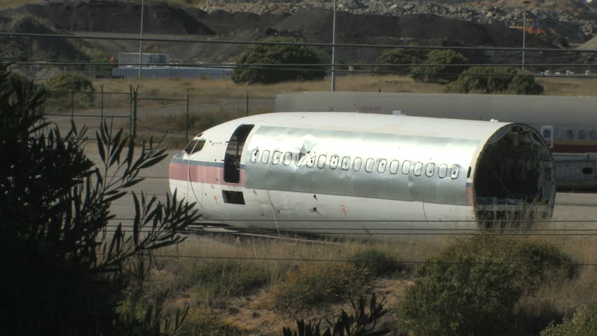 This is a medium shot of two airplanes sitting in the California sun rusting and rotting. They look like they were dismantled decades ago.