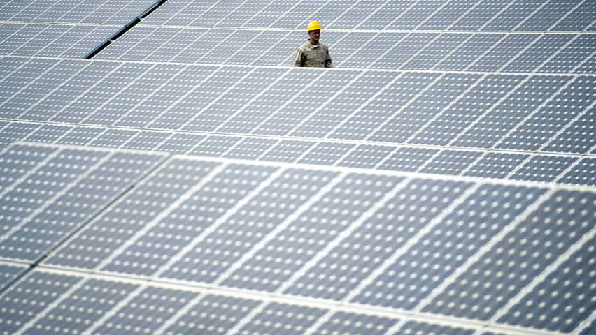 Technician walking through  solar panels; Full HD Photo JPEG