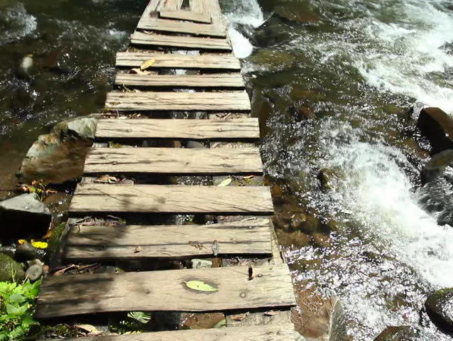 Crossing an Andean torrent on a dangerous bridge, Ecuador