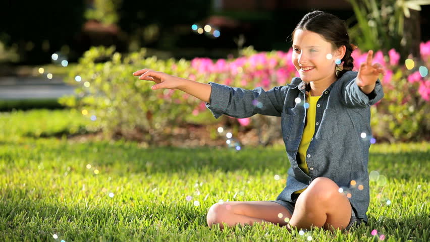 Happy young caucasian girl laughing at play bubbles