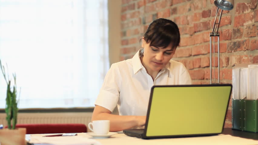 Young attractive businesswoman drinking coffee and smiling to camera