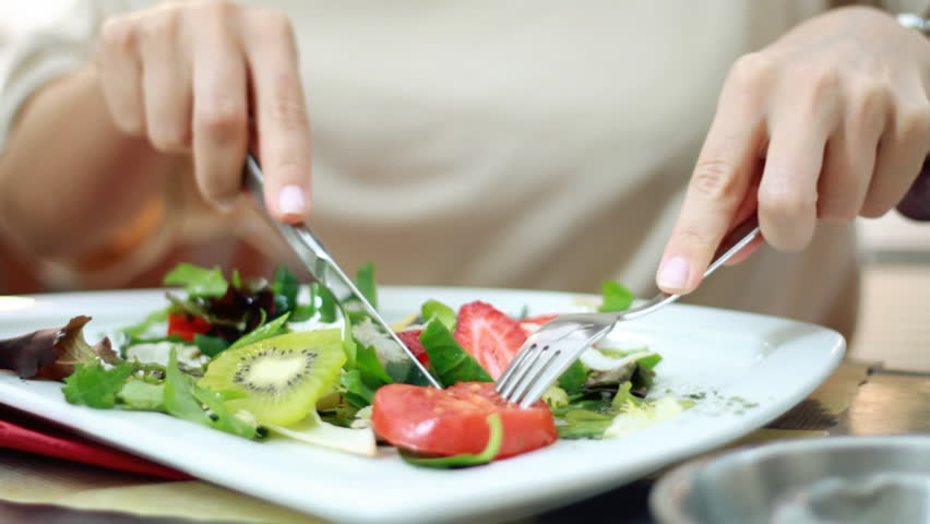 Woman eating salad, close up