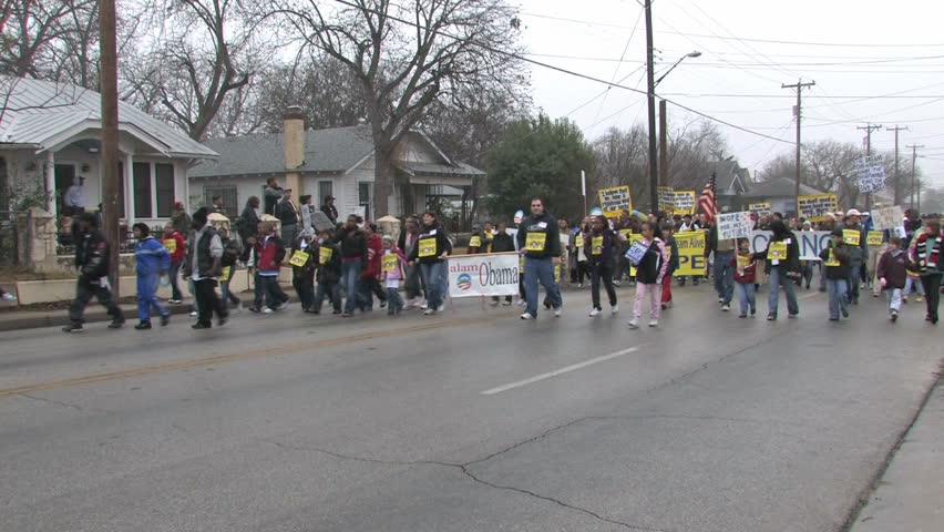 Video political signs for Obama in the largest Martin Luther King MLK March in the USA in San Antonio, Texas. Misty rainy day in January. Man beating on drum as he marches. Editorial. 