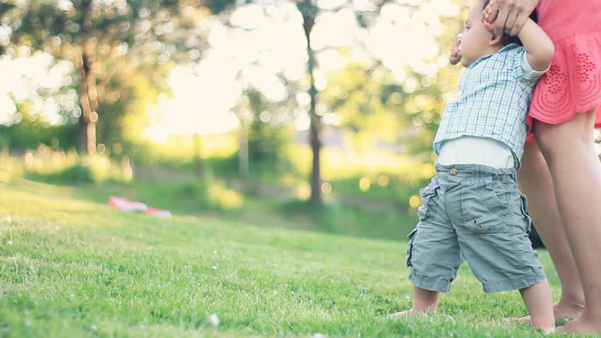 Baby first steps on grass, dolly shot