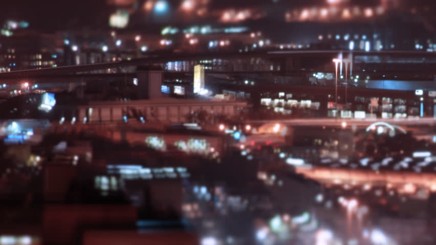 Looping night time grungy long-exposure timelapse pan over city streets, with throbbing blurs, light streaks, and twitching double exposures.  1080p HD