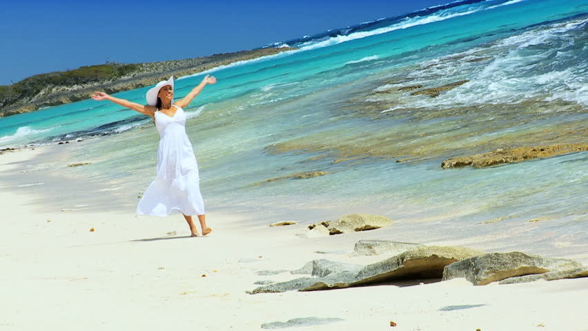 Beautiful elegant female reveling in her lifestyle beside a tropical ocean