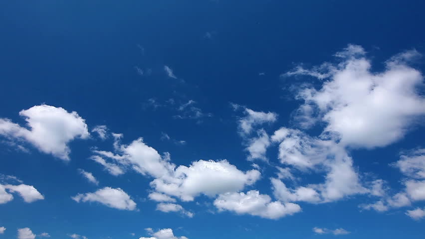 Time lapse clip of white fluffy clouds over blue sky