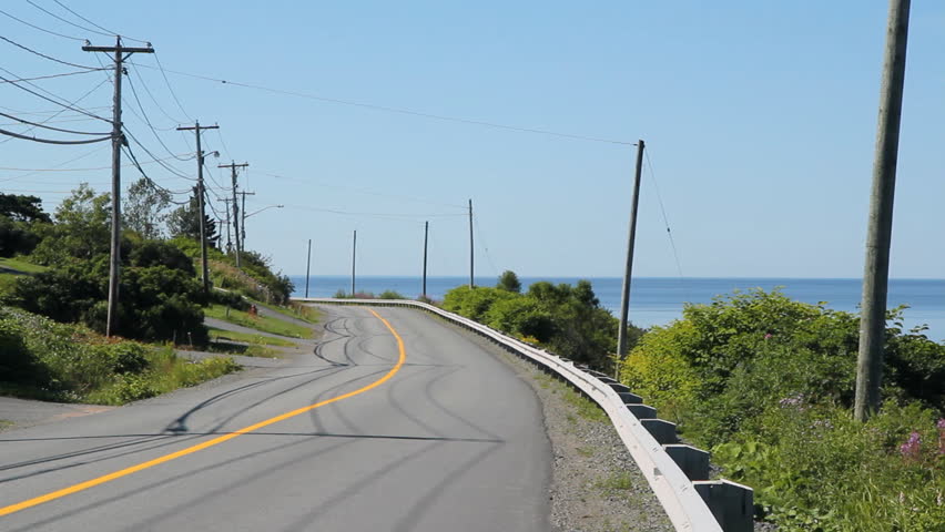 Oceanside road. Car goes past on road beside the sea. Sounds of birds singing. Saint John, New Brunswick. 
