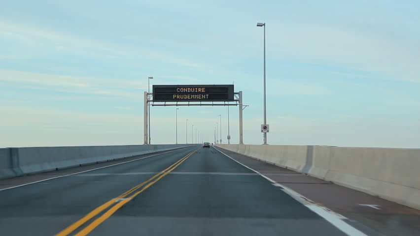 Confederation bridge. Crossing the Confederation bridge. Seagull flies from light halfway through. Confederation Bridge joins New Brunswick to Prince Edward Island in Canada. 