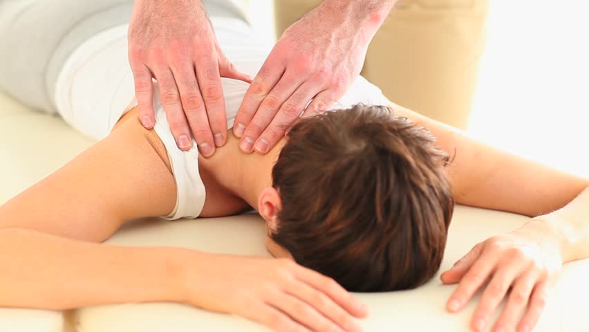 Masseur massaging a woman in a room