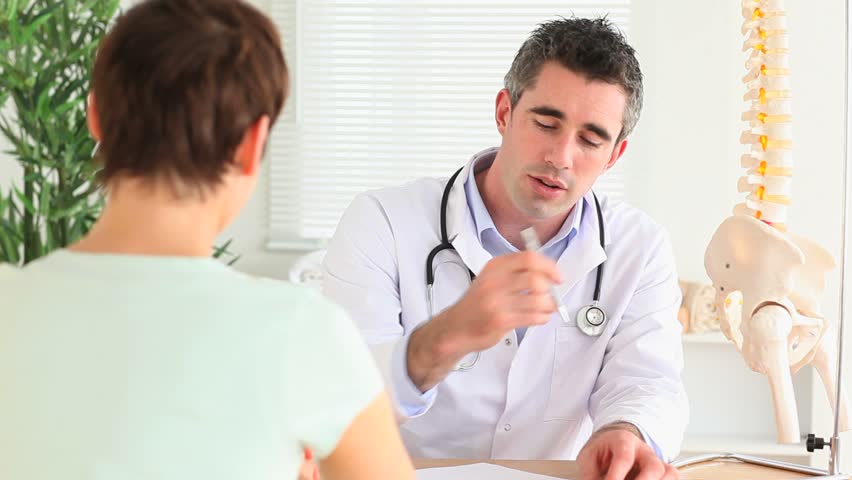 Doctor writing a prescription for his patient