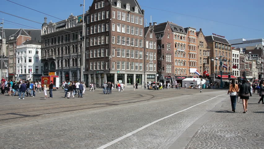 AMSTERDAM, HOLLAND - AUGUST 1: Tram drives along Dam square, with tourists crossing the street, on August 1, 2011 in Amsterdam, Holland. 