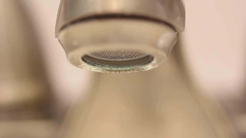 Looping macro footage of a faucet dripping with visible corrosion.