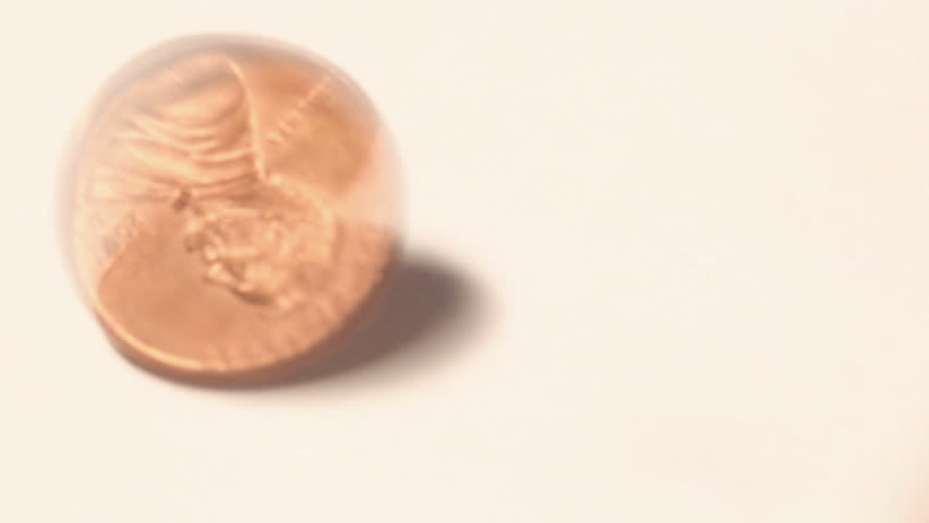 Close up of a spinning United States One Cent piece (penny) and coming to a stop heads up on a white background.
