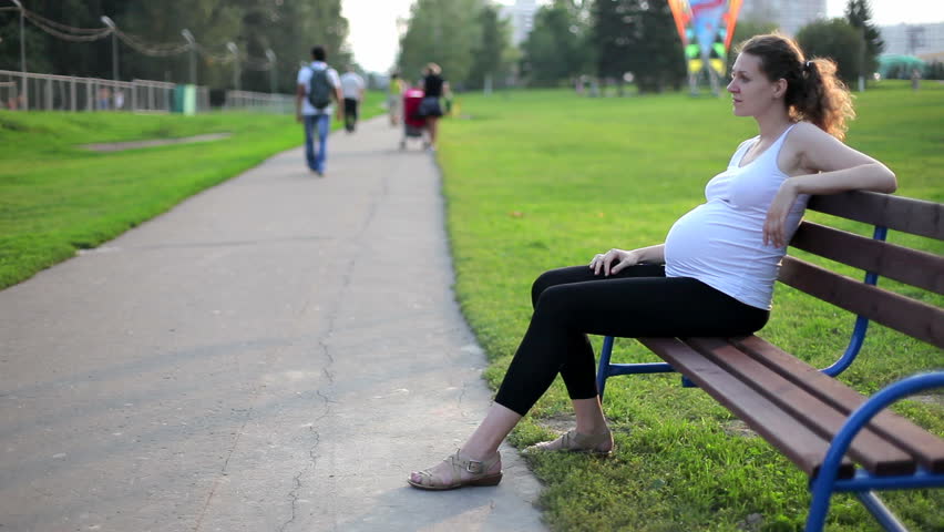 Young pregnant woman relaxing in park