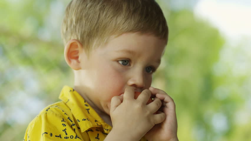 Boy eating an apple.