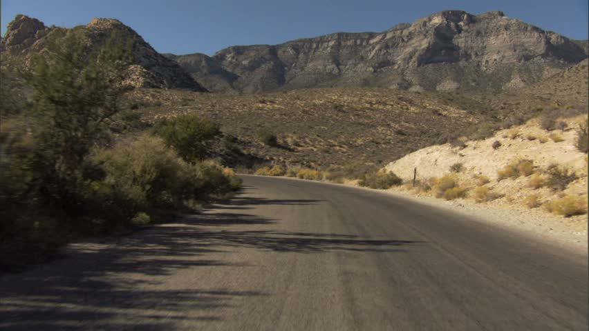 car driving in southwest territory, usa past a cyclist
