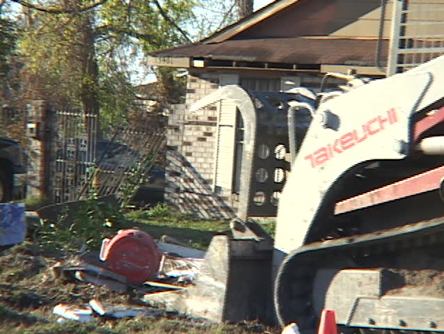 NEW ORLEANS, LA - CIRCA 2005: A bulldozer shovels up household remains after Hurricane Katrina circa 2005 in New Orleans, LA.