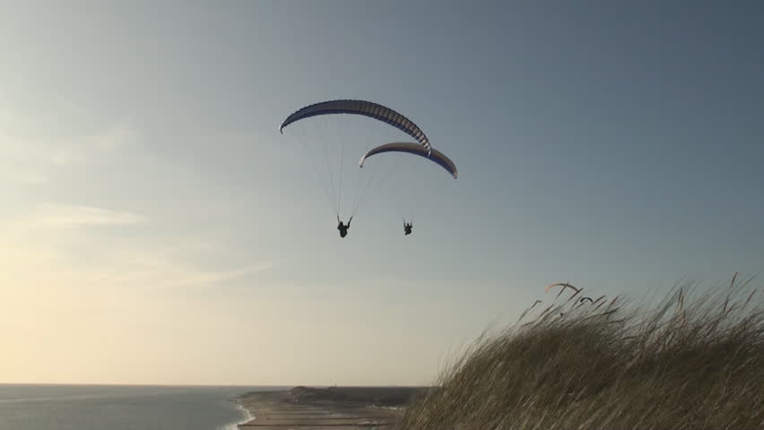 Parasailer sailing over the dunes and the beach along the coast of the province Zealand in the Netherlands. 