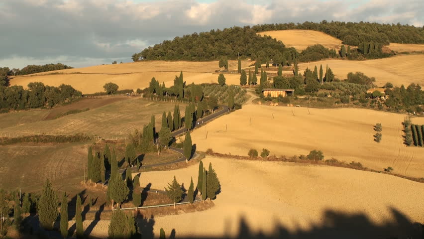 The road to the little town of Monticchiello as the sun sets over the Val d'Orcia in Tuscany, Italy 