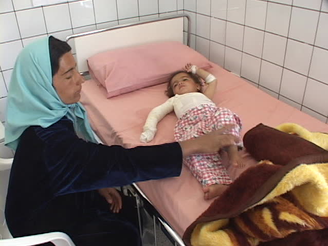 IRAQ - CIRCA 2003: An Iraqi mother tends to her injured baby in a hospital.The casualties of war circa 2003 in Iraq.