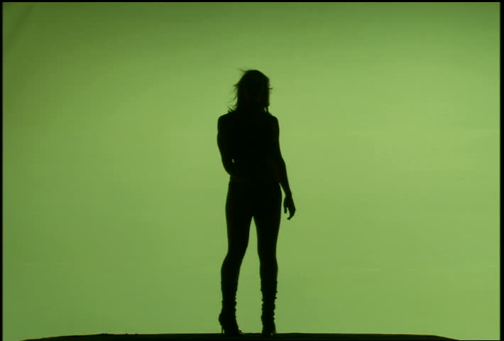 A silhouetted woman dancing against green background
