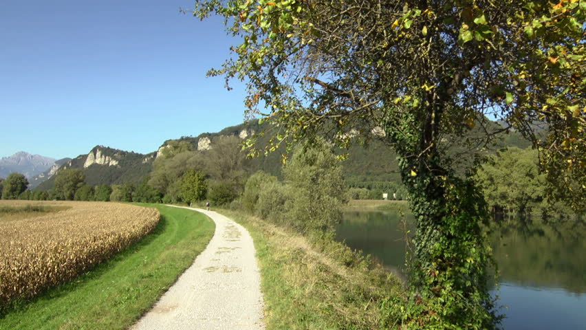 sports activity: young adult cyclist riding mountain bike in the countryside on dirt road. Crane shot