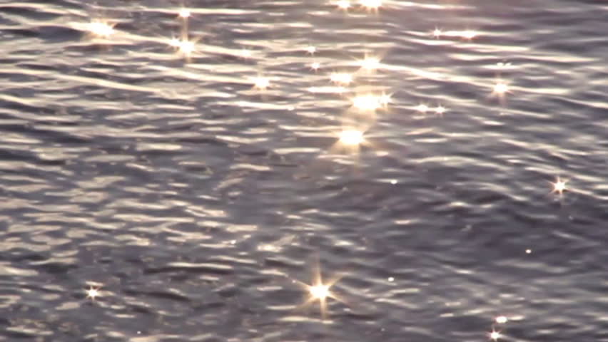 Out of focus star burst reflections from sunlight hitting and reflecting on water.