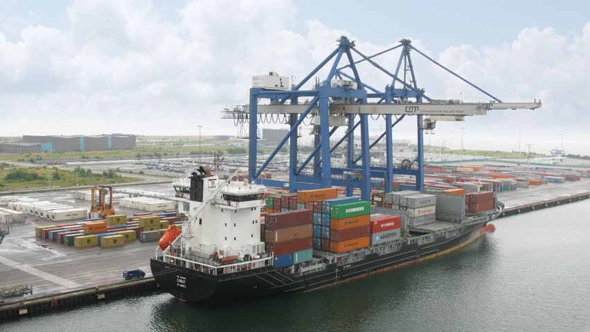COPENHAGEN, DENMARK - JULY 12: Trucks load ship with containers on July 12, 2011 in Copenhagen, Denmark. 