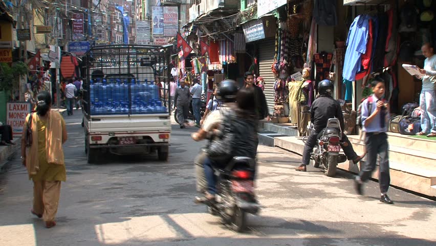 KATHMANDU - CIRCA 2010: People, cars and bikes circulate through the city circa 2010 in Kathmandu.
