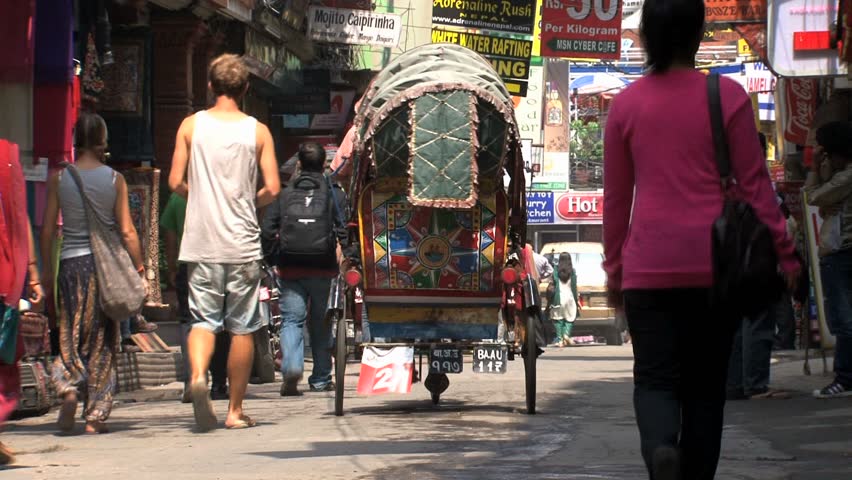 KATHMANDU - CIRCA 2010: People, cars and bikes circulate through the city circa 2010 in Kathmandu.