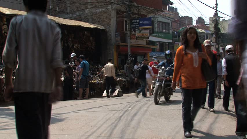 KATHMANDU - CIRCA 2010: People, cars and bikes circulate through the city circa 2010 in Kathmandu.