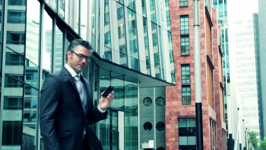Business man leaving office and answering phone call