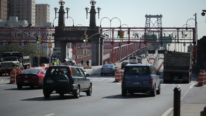 traffic moving onto the Williamsburg bridge from the Manhattan side with focus on the distant bridge and shallow depth of field to obscure license plates etc.