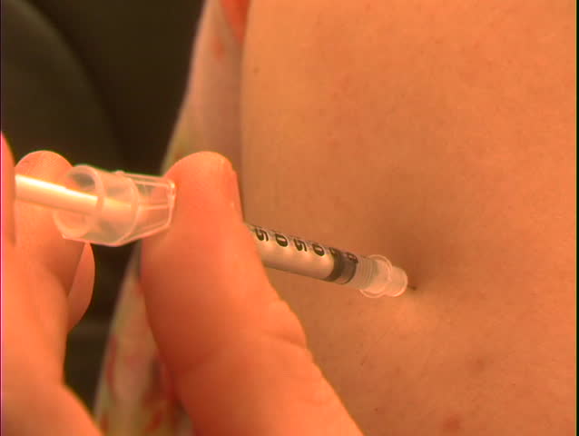 A man administers an insulin injection into his belly.